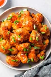  Buffalo Cauliflower Wings Buffalo Cauliflower Wings: Who loves wings to eat? Its taste and crispy flavor insisted on loving them. But today our recipe is not for the chicken wings that are on the Buffalo Cauliflower Wings. It's more crispy and spicy and inside the soft and smooth taste of cauliflower. Their balance taste and smooth sweet taste are amazing. Cauliflower Wings are delicious, with crispy edges and a very tangy flavor. I really love their taste and yummy flavor. Mostly, I love to eat during games. Best snack for me. For many years, most peoples want only chicken wings, But when I try the Buffalo Cauliflower Wings. You do not imagine I really love the taste of the Cauliflower Wings. So when I want to eat some tasty and yummy food, I always make Cauliflower Wings. It is very easy to make and gives you a crispy taste. Midnight movie enjoying and TV drama sessions and friend gathering these Buffalo Cauliflower Wings gives you an amazing and delicious taste. In starting, I make just only chicken wings but when I make and try this recipe I can't stop myself to make it again and again and eat. Its taste and perfect balance of flavors is amazing. Ingredients: Those ingredients here use in the recipe make it more crispy and flavorful. ¾ cup water 2 teaspoon paprika ½ teaspoon sea salt 2 teaspoon garlic powder 2 teaspoon onion powder Vegan Ranch, optional, for dipping Buffalo Red Sauce, for brushing and topping ⅔ cup all-purpose flour spooned and leveled 2 head cauliflower, 2 pounds, broken into large pieces My Buffalo Cauliflower Wing Sauce: To enhance the taste of My Buffalo Cauliflower Wing, make it for My favorite Buffalo Cauliflower Wing Sauce. This sauce tastes the very rich and original flavor of red-hot chili. This sauce's taste and tangy flavor increase our recipe taste. You must try this sauce. This is the amazing sauce I always make in my own kitchen. Because I always trust the homemade recipe and its original taste. So this Buffalo Cauliflower Wing Sauce make with Frank’s Red Hot chili, melted Butter, and vinegar. Sauce Recipe: These are ingredients are easily available in your kitchen. You also use this sauce for other snacks, wings, fries, and many more recipes. These are also available in the market. You can also purchase these Sauces and also use them in the recipe and enjoy the snacks every time. I start with the melted butter because they give a good flavor and creamy thick texture to our recipe. I never forget to add any kind of vinegar to my recipe, especially in sauces. Vinegar gives a good and amazing taste to your all recipes. I like most to add this to the recipe. I also add garlic powder to some black paper and a species and red chili powder. Also, some time uses honey in my sauce to make it thick and more delicious to eat. If you do not like the vegan you do not use it. It's optional for you, but I love their taste, so I can use them. How to make it: When you prepare your sauce, then going to make the Buffalo wings our today's crispy recipe. First Step: So let's start our recipe by cutting off Cauliflower. Make sure to cut the medium-large size of Buffalo Cauliflower. When you cut the in pieces, then prepare the batter for the coating. Make a simple batter in a bowl add flour, cornstarch, garlic powder, onion powder, paprika, salt, and water. Make sure your batter is thick enough for coating the Cauliflower. This spice batter enhances the crispy taste of the recipe. Our wing's edges have a tangier flavor and are tasty. Second Step: Cornstarch, garlic powder, and onion powder increase the delicious flavor of the wings. But inside the buffalo Cauliflower is soft and smooth to eat and yummy in flavor. Now our coating is complete, that time to fry or bake our crispy wings. Let's bake it in a single layer you can set the wings on the baking sheet. I'll give you the fried effect and taste without frying the wings. Third Step: Bake at 450 °F for 10 minutes the buffalo Cauliflower wings after 10 minutes flip the and bake the wings 10 minutes more for a crispy and crunchy taste. Remove our wings from the oven and with the help of a brush coat the buffalo Cauliflower sauce on the wings. Again put them in the oven and bake them for more dark color and crispy flavor. After 10 to 12 minutes more bake the edges of the buffalo Cauliflower to dark brown and look crispy. Fourth Step: You can hold yourself to eat these yummy wings. When you see the wings properly bake and are ready to eat then remove them from the oven more buffalo sauce and add to the wings with the help of a brush. And now serve the hot and warm spicy wings with buffalo Cauliflower wings sauce. These wings are fantastic in flavor. Tips for Making the BEST Wings: Baking Sheet: You must use the Baking sheet to bake these wings. If you do not use this sheet your Buffalo Cauliflower Wings after 10 minutes when you flip them again bake will stick to the baking sheet. Not quickly remove them because the batter on the wings is soft and breaks if we try to remove it. Also, use a brush to again coat the sauce on the wings. Without a brush, our crispy wings get a break, and we do not disturb their shape. Properly Bake: Properly check, their edges bake perfectly and look dark brown and yummy to look. You must try to sauce coat on the wings because it enhances the flavor of the Buffalo Cauliflower Wings. Serving and Enjoy: The hot Buffalo Cauliflower wings give you the best taste and enjoyment. So eat them with hot chili sauce in the nighttime in front of your TV and movies and with friends/ They very suitable recipe for every event and happy your mood. Make your day to try the best today recipe and fresh your mood to eat delicious wings. Freeze and Store: You can also store these wings for 3 days. You put them in a container and store them in the fridge and freeze the wings. When you want to eat, open the fridge and bake the yummy Wings.