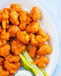  Buffalo Cauliflower Wings Buffalo Cauliflower Wings: Who loves wings to eat? Its taste and crispy flavor insisted on loving them. But today our recipe is not for the chicken wings that are on the Buffalo Cauliflower Wings. It's more crispy and spicy and inside the soft and smooth taste of cauliflower. Their balance taste and smooth sweet taste are amazing. Cauliflower Wings are delicious, with crispy edges and a very tangy flavor. I really love their taste and yummy flavor. Mostly, I love to eat during games. Best snack for me. For many years, most peoples want only chicken wings, But when I try the Buffalo Cauliflower Wings. You do not imagine I really love the taste of the Cauliflower Wings. So when I want to eat some tasty and yummy food, I always make Cauliflower Wings. It is very easy to make and gives you a crispy taste. Midnight movie enjoying and TV drama sessions and friend gathering these Buffalo Cauliflower Wings gives you an amazing and delicious taste. In starting, I make just only chicken wings but when I make and try this recipe I can't stop myself to make it again and again and eat. Its taste and perfect balance of flavors is amazing. Ingredients: Those ingredients here use in the recipe make it more crispy and flavorful. ¾ cup water 2 teaspoon paprika ½ teaspoon sea salt 2 teaspoon garlic powder 2 teaspoon onion powder Vegan Ranch, optional, for dipping Buffalo Red Sauce, for brushing and topping ⅔ cup all-purpose flour spooned and leveled 2 head cauliflower, 2 pounds, broken into large pieces My Buffalo Cauliflower Wing Sauce: To enhance the taste of My Buffalo Cauliflower Wing, make it for My favorite Buffalo Cauliflower Wing Sauce. This sauce tastes the very rich and original flavor of red-hot chili. This sauce's taste and tangy flavor increase our recipe taste. You must try this sauce. This is the amazing sauce I always make in my own kitchen. Because I always trust the homemade recipe and its original taste. So this Buffalo Cauliflower Wing Sauce make with Frank’s Red Hot chili, melted Butter, and vinegar. Sauce Recipe: These are ingredients are easily available in your kitchen. You also use this sauce for other snacks, wings, fries, and many more recipes. These are also available in the market. You can also purchase these Sauces and also use them in the recipe and enjoy the snacks every time. I start with the melted butter because they give a good flavor and creamy thick texture to our recipe. I never forget to add any kind of vinegar to my recipe, especially in sauces. Vinegar gives a good and amazing taste to your all recipes. I like most to add this to the recipe. I also add garlic powder to some black paper and a species and red chili powder. Also, some time uses honey in my sauce to make it thick and more delicious to eat. If you do not like the vegan you do not use it. It's optional for you, but I love their taste, so I can use them. How to make it: When you prepare your sauce, then going to make the Buffalo wings our today's crispy recipe. First Step: So let's start our recipe by cutting off Cauliflower. Make sure to cut the medium-large size of Buffalo Cauliflower. When you cut the in pieces, then prepare the batter for the coating. Make a simple batter in a bowl add flour, cornstarch, garlic powder, onion powder, paprika, salt, and water. Make sure your batter is thick enough for coating the Cauliflower. This spice batter enhances the crispy taste of the recipe. Our wing's edges have a tangier flavor and are tasty. Second Step: Cornstarch, garlic powder, and onion powder increase the delicious flavor of the wings. But inside the buffalo Cauliflower is soft and smooth to eat and yummy in flavor. Now our coating is complete, that time to fry or bake our crispy wings. Let's bake it in a single layer you can set the wings on the baking sheet. I'll give you the fried effect and taste without frying the wings. Third Step: Bake at 450 °F for 10 minutes the buffalo Cauliflower wings after 10 minutes flip the and bake the wings 10 minutes more for a crispy and crunchy taste. Remove our wings from the oven and with the help of a brush coat the buffalo Cauliflower sauce on the wings. Again put them in the oven and bake them for more dark color and crispy flavor. After 10 to 12 minutes more bake the edges of the buffalo Cauliflower to dark brown and look crispy. Fourth Step: You can hold yourself to eat these yummy wings. When you see the wings properly bake and are ready to eat then remove them from the oven more buffalo sauce and add to the wings with the help of a brush. And now serve the hot and warm spicy wings with buffalo Cauliflower wings sauce. These wings are fantastic in flavor. Tips for Making the BEST Wings: Baking Sheet: You must use the Baking sheet to bake these wings. If you do not use this sheet your Buffalo Cauliflower Wings after 10 minutes when you flip them again bake will stick to the baking sheet. Not quickly remove them because the batter on the wings is soft and breaks if we try to remove it. Also, use a brush to again coat the sauce on the wings. Without a brush, our crispy wings get a break, and we do not disturb their shape. Properly Bake: Properly check, their edges bake perfectly and look dark brown and yummy to look. You must try to sauce coat on the wings because it enhances the flavor of the Buffalo Cauliflower Wings. Serving and Enjoy: The hot Buffalo Cauliflower wings give you the best taste and enjoyment. So eat them with hot chili sauce in the nighttime in front of your TV and movies and with friends/ They very suitable recipe for every event and happy your mood. Make your day to try the best today recipe and fresh your mood to eat delicious wings. Freeze and Store: You can also store these wings for 3 days. You put them in a container and store them in the fridge and freeze the wings. When you want to eat, open the fridge and bake the yummy Wings.